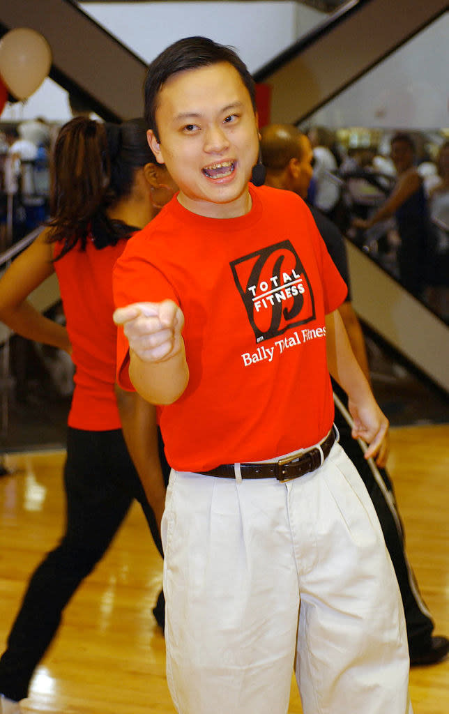 William wearing a Bally Total Fitness shirt and mic while in a class