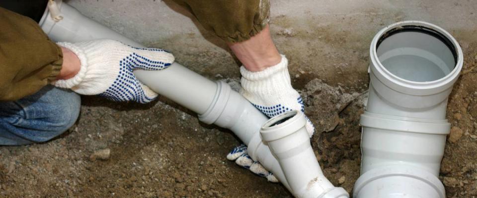 Plumber assembling pvc sewage pipes