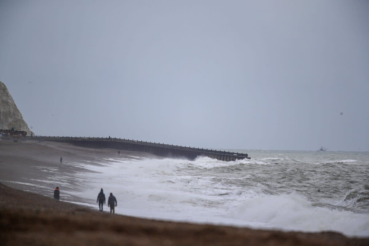 People walk on the beach at Seaford in Sussex (Steve Parsons/PA) (PA Archive)
