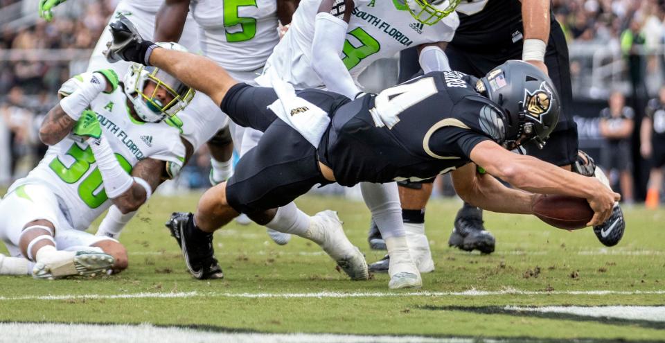 UCF quarterback Parker Navarro (14) dives into the end zone for a touchdown during an NCAA college football game against South Florida, Friday, Nov. 26, 2021, in Orlando, Fla. (Willie J. Allen Jr./Orlando Sentinel via AP)