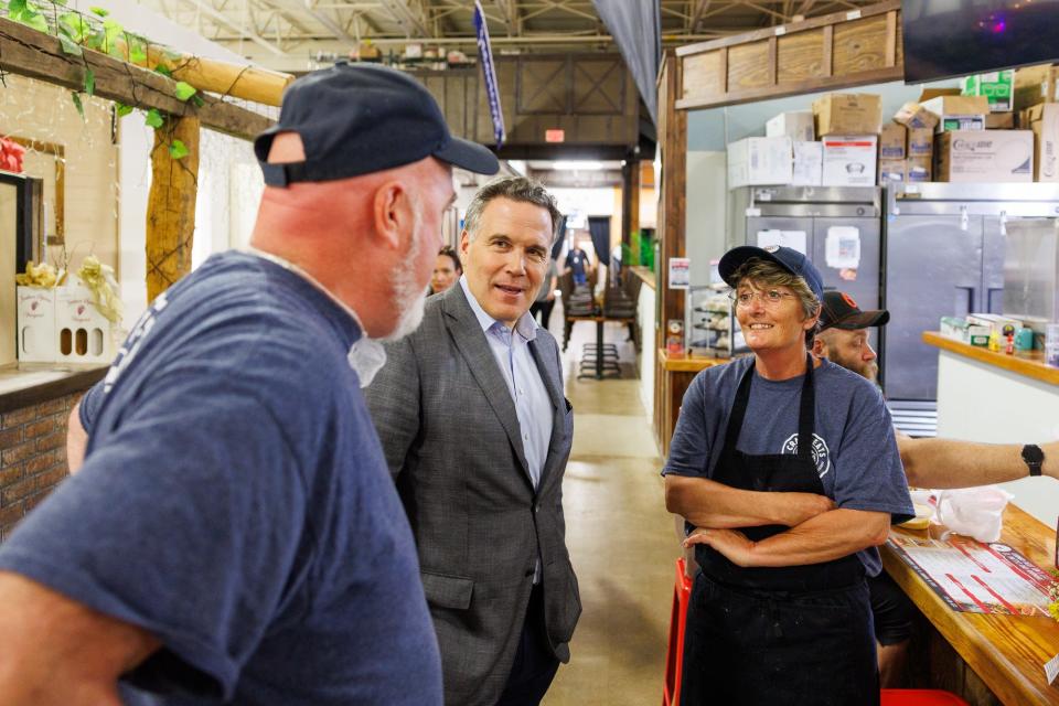 Republican Senate candidate Dave McCormick (center) speaks with John Schmidt, left, and Ingrid Schmidt, right, owners of Craft Eats, during a tour of the Markets at Hanover, Wednesday, May 8, 2024, in Penn Township. McCormick and John Schmidt worked together in previous careers, McCormick shared.