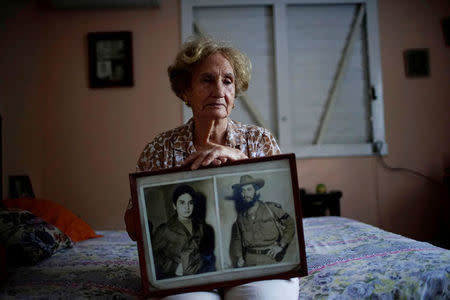 Former rebel Juana Ramirez, 81, poses for a picture holding a photograph of her with her late husband and rebel fighter Luiz Perez, Havana, Cuba, April 4, 2018. Picture taken on April 4, 2018. REUTERS/Alexandre Meneghini