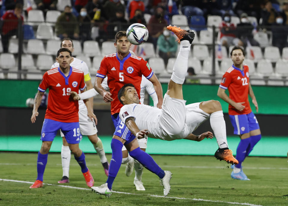 FILE - Uruguay's Luis Suarez, center, does a back kick to score his side's opening goal against Chile during a qualifying soccer match for the FIFA World Cup Qatar 2022 at San Carlos de Apoquindo stadium in Santiago, Chile, Tuesday, March 29, 2022. (Alberto Valdes/Pool Via AP, File)