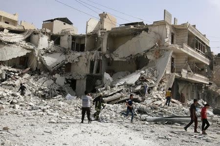 People inspect a damaged site after airstrikes on the rebel held al-Qaterji neighbourhood of Aleppo, Syria September 21, 2016. REUTERS/Abdalrhman Ismail