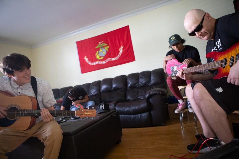 Kiowa Wolfe plays guitar with his two sons, K.J., left, and Kyle at their home in Santee, Aug. 5, 2021.