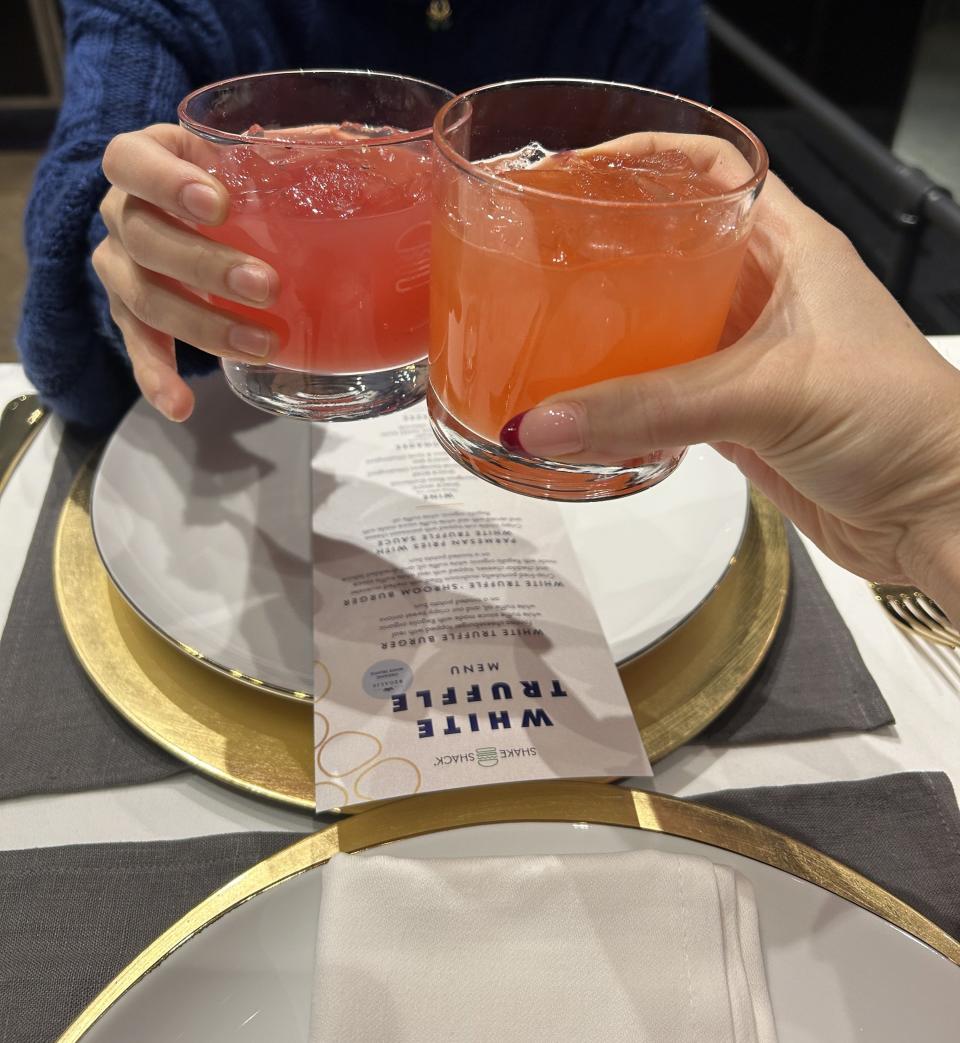 Two people touching glasses at a table