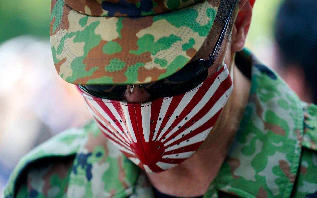 A man pays his respects to the war dead at Yasukuni Shrine on Saturday - AP Photo/Eugene Hoshiko