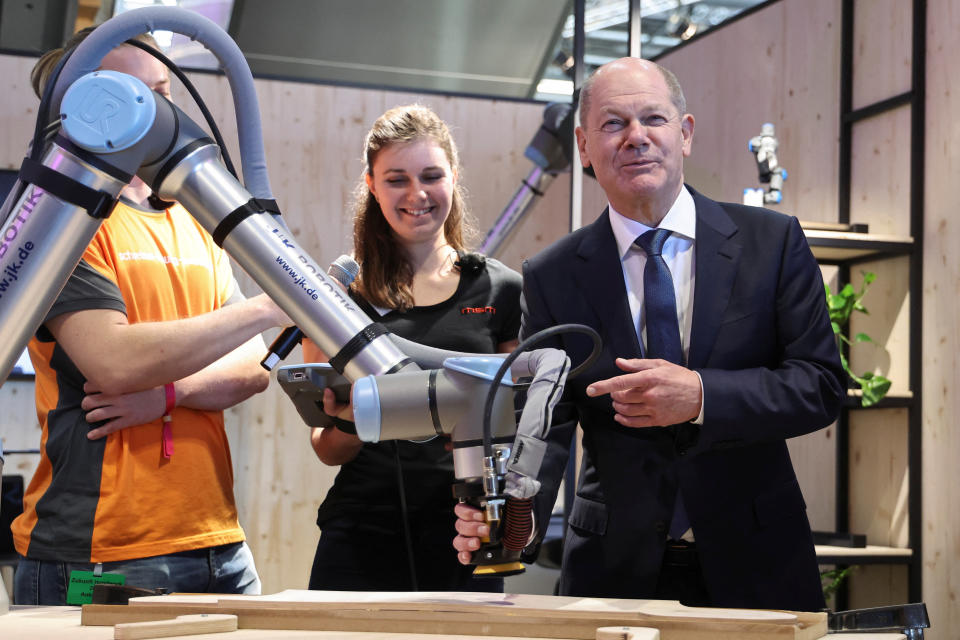 German Chancellor Olaf Scholz holds a robotic arm during the German Confederation of Skilled Crafts (Zentralverband des Deutschen Handwerks, ZDH) leaders' meeting at the ZDH fair in Munich, Germany, March 10, 2023. REUTERS/Lukas Barth
