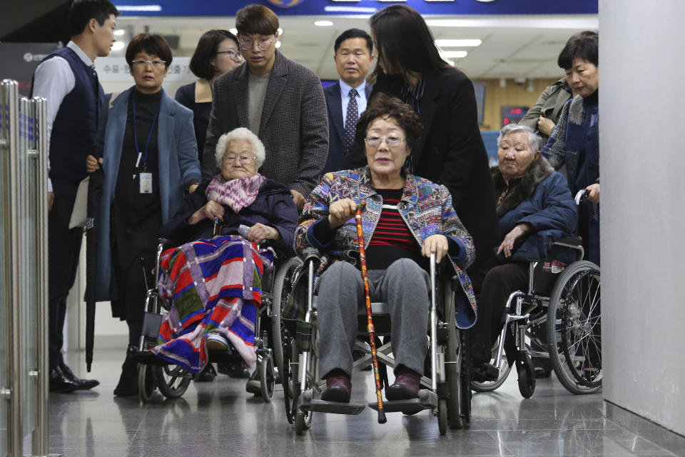 Former South Korean comfort women, Lee Yong-soo, center, Lee Ok-seon and Gil Won-ok, right, leave the Seoul Central District Court in Seoul, South Korea, Wednesday, Nov. 13, 2019. A Seoul court on Wednesday began hearing a long-awaited civil case filed against the Japanese government by South Korean women who were forced to work in Japan's World War II military brothels. (AP Photo/Ahn Young-joon)
