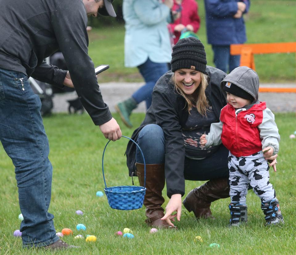 Brian and Becky Frank help Leo Frank collect eggs Saturday during the North Canton Jaycees' annual Easter Egg Hunt in North Canton. More than 6,500 eggs were available for the more than 230 children who attended the event.