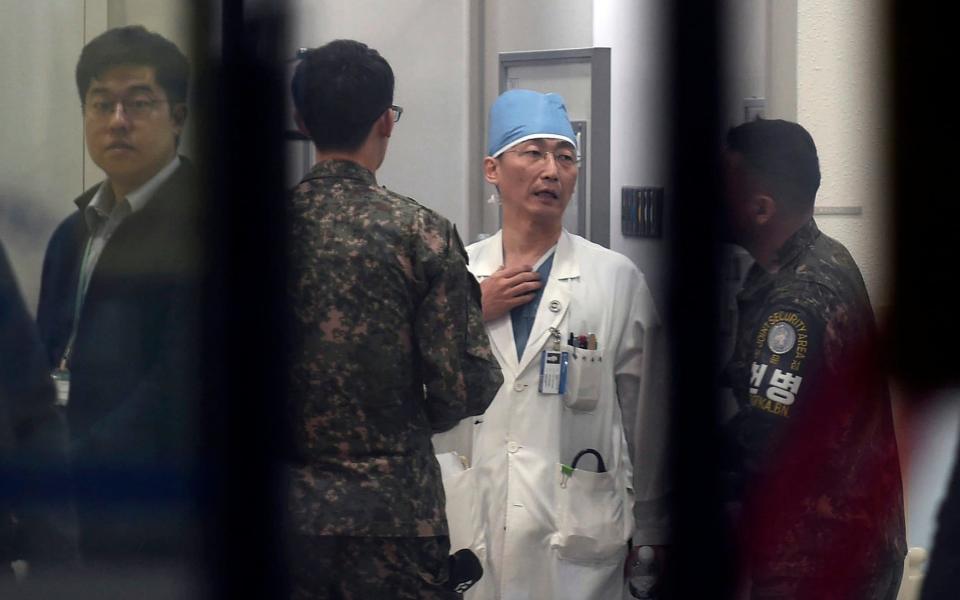 South Korean soldiers talk with a medic preparing to treat an unidentified injured person, unseen, believed to be a North Korean soldier, at a hospital in Suwon - Newsis