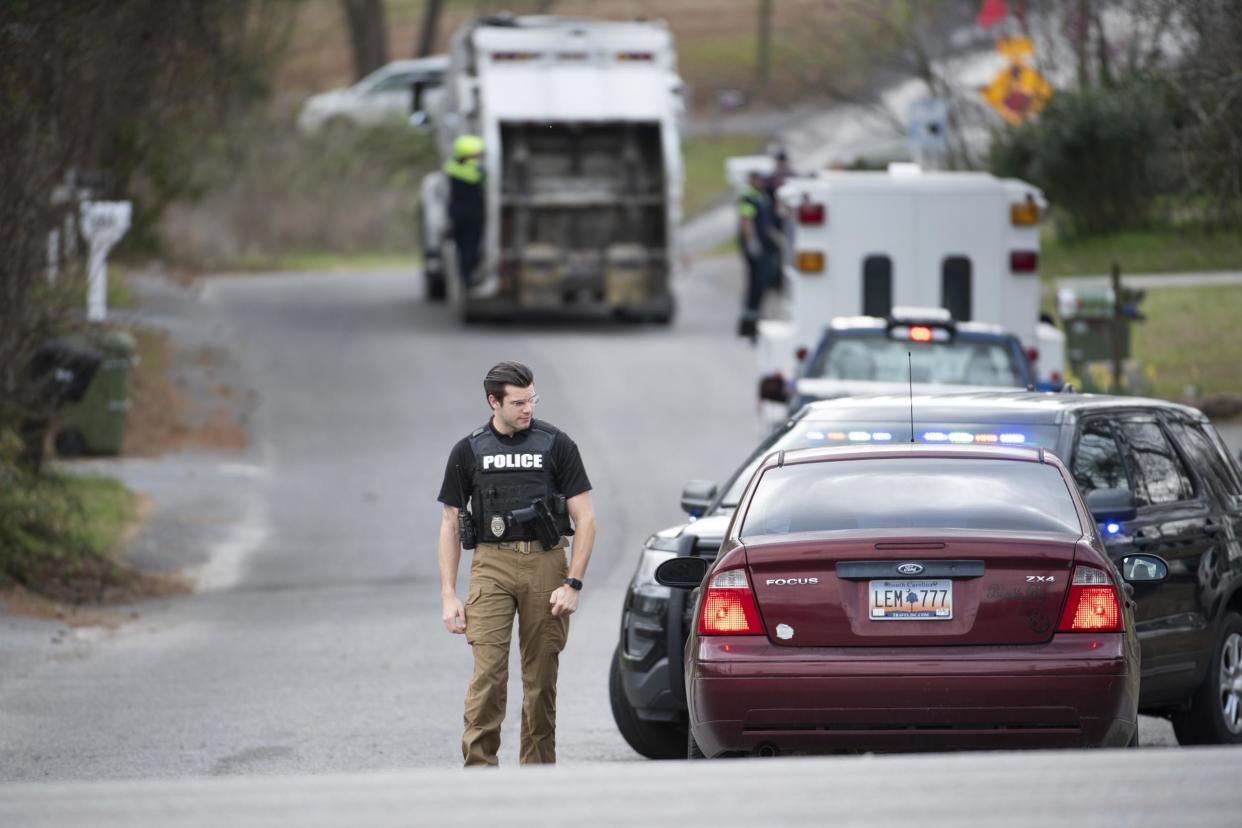 A Cayce police officer approaches a vehicle at a road block near an entrance to the Churchill Heights neighborhood where Faye Swetlik went missing from her front yard: AP Photo/Sean Rayford