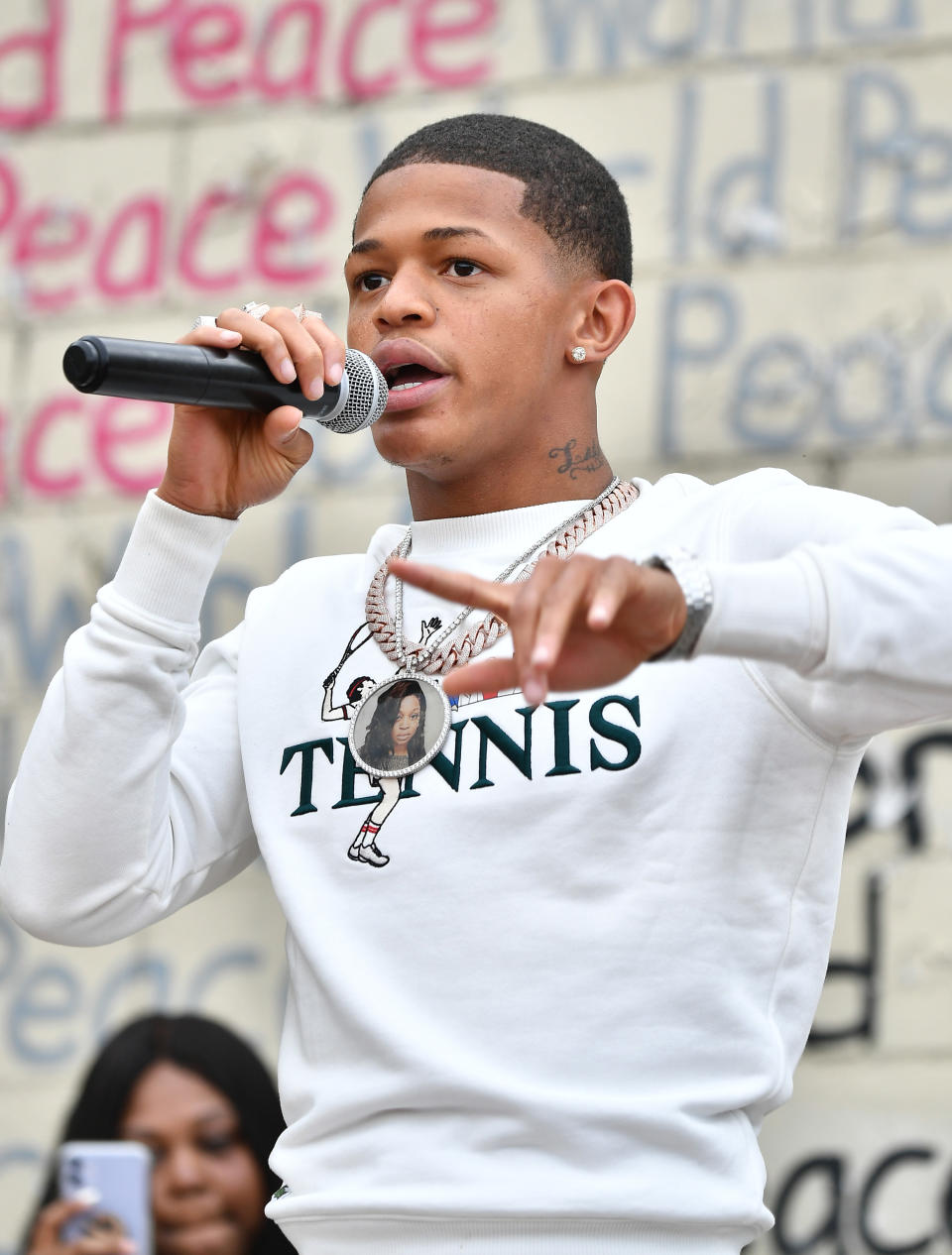 YK Osiris performs live on stage with a mic in hand.