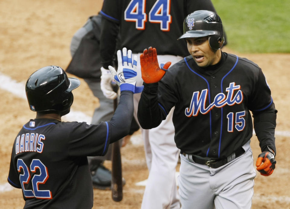 New York Mets batter Carlos Beltran (R) is congratulated by teammate Willie Harris (22) after Beltran scored his second home run of the day, a two-run homer, against the Colorado Rockies in the seventh inning of their MLB National League baseball game in Denver May 12, 2011. REUTERS/Rick Wilking (UNITED STATES - Tags: SPORT BASEBALL)