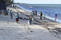 People walk along the Jomo Kenyatta Public Beach in Mombasa, Kenya, Friday April 2, 2021. Most of the holiday makers were turned away by security officers saying that the government had closed all public places including the beach, due to the COVID-19 pandemic. (AP Photo/Gideon Maundu)