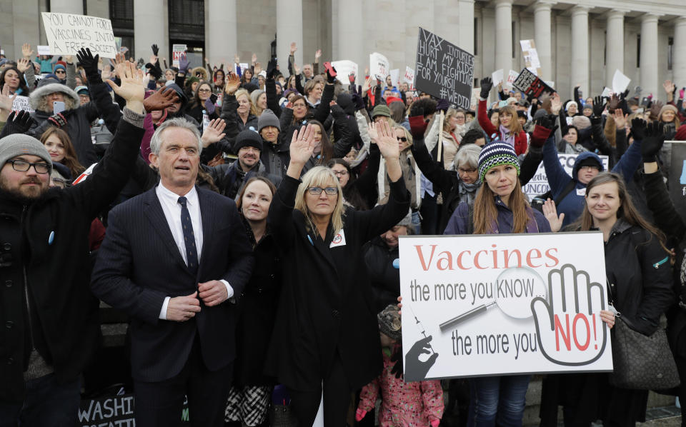 FILE - Robert F. Kennedy, Jr., left, stands with protesters at the Capitol in Olympia, Wash., on Feb. 8, 2019, where they opposed a bill to tighten measles, mumps and rubella vaccine requirements for school-aged children. (AP Photo/Ted S. Warren, File)