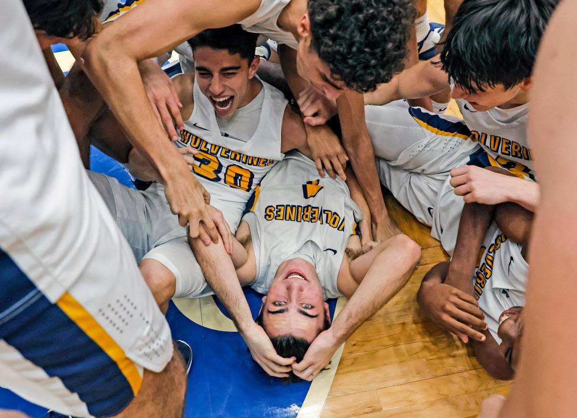 Belen Jesuit’s Javier Rosell (4), at bottom center, gets piled on by teammates after defeating Mainland for the FHSAA boys basketball Class 5A State Championship at the RP Funding Center in Lakeland, Florida on Saturday, March 4, 2023.