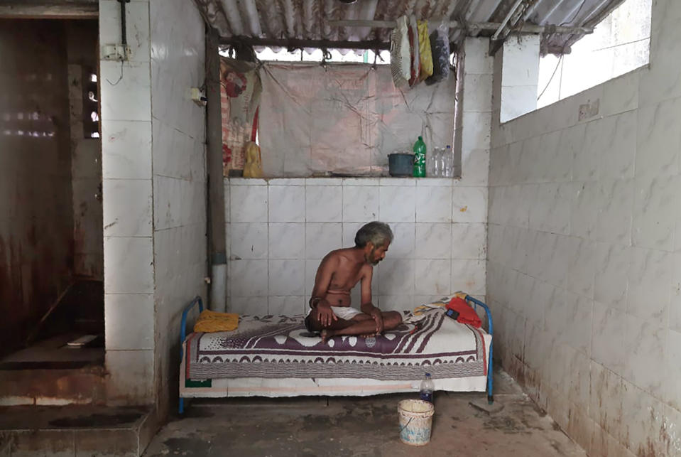 Raja Kadam rests on his bed inside a toilet complex in Dharavi, one of Asia's largest slums, in Mumbai, India, Saturday, May 16, 2020. Kadam, who has lived in this toilet complex for nine years, says toilets here are disinfected once daily. Dharavi has had more than 1,800 confirmed COVID-19 cases, and is among Mumbai’s most affected pockets. Without reliable running water in it's 500 toilet complexes, one of the most worrying concern for authorities is sanitation. (Kunal Kanase via AP)