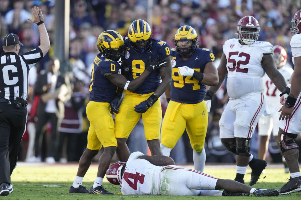 Alabama quarterback Jalen Milroe (4) lies on the ground after being sacked by Michigan defensive end Derrick Moore (8) during the first half in the Rose Bowl CFP NCAA semifinal college football game Monday, Jan. 1, 2024, in Pasadena, Calif. (AP Photo/Mark J. Terrill)