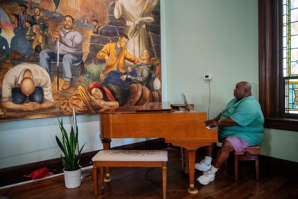James Blount, who goes by "Brother James," plays the piano in the sanctuary at Haywood Street Congregation, November 8, 2023. Blount is also featured in the fresco to the left.