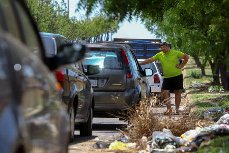 A man stands next to vehicles waiting in line in an attempt to refuel at a gas station of the state oil company PDVSA in Ciudad Guayana, Venezuela, May 17, 2019. REUTERS/William Urdaneta