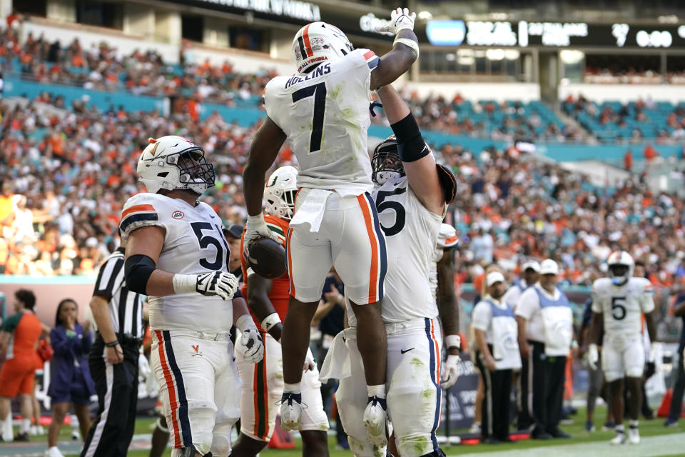 Virginia running back Mike Hollins (7) celebrates after scoring a touchdown during the second half of an NCAA college football game against Miami, Saturday, Oct. 28, 2023, in Miami Gardens, Fla. (AP Photo/Lynne Sladky)