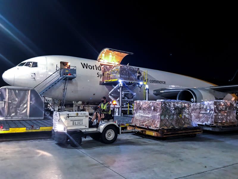 Pallets of surgical gowns are unloaded from an international cargo plane in response to the coronavirus disease outbreak in Miami