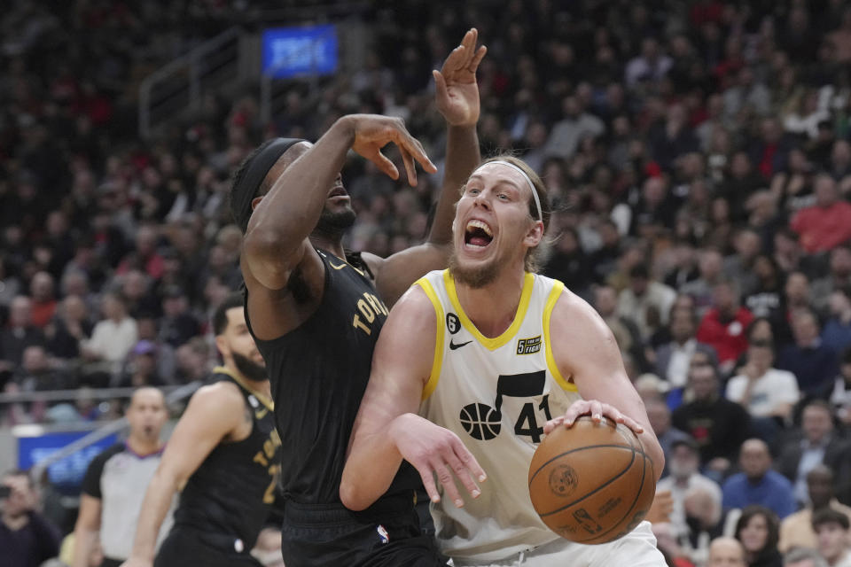 Utah Jazz's Kelly Olynyk, right, drives against Toronto Raptors' Precious Achiuwa during the first half of an NBA basketball game Friday, Feb. 10, 2023, in Toronto. (Chris Young/The Canadian Press via AP)