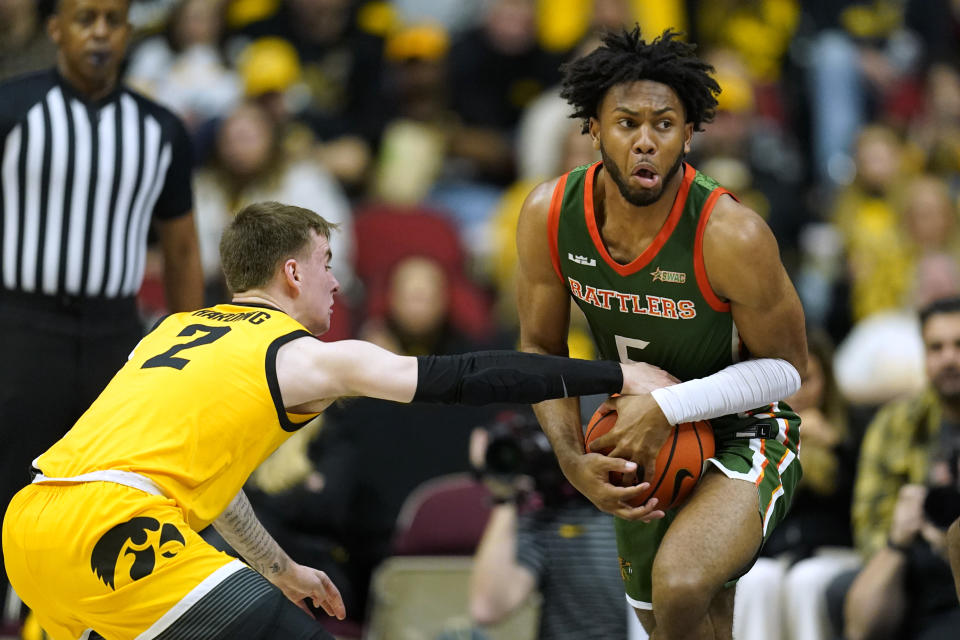 Iowa guard Brock Harding (2) tries to steal the ball from Florida A&M forward Keith Lamar (5) during the first half of an NCAA college basketball game, Saturday, Dec. 16, 2023, in Des Moines, Iowa. (AP Photo/Charlie Neibergall)