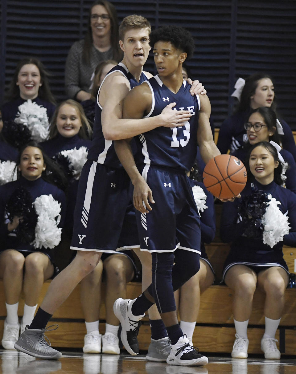 Yale's Blake Reynolds, left, embraces teammate Trey Phills during the first half of an NCAA college basketball game for the Ivy League championship against Harvard at Yale University in New Haven, Conn., Sunday, March 17, 2019, in New Haven, Conn. (AP Photo/Jessica Hill)