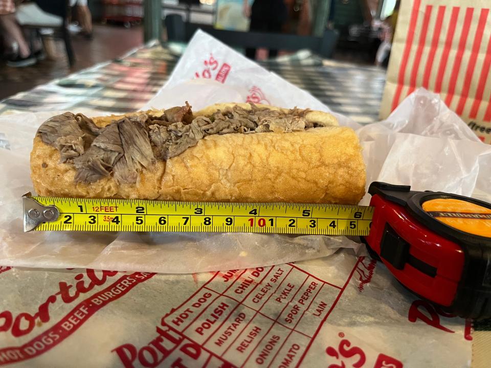 A tape measure next to a Portillo's sandwich, measuring 6 inches.