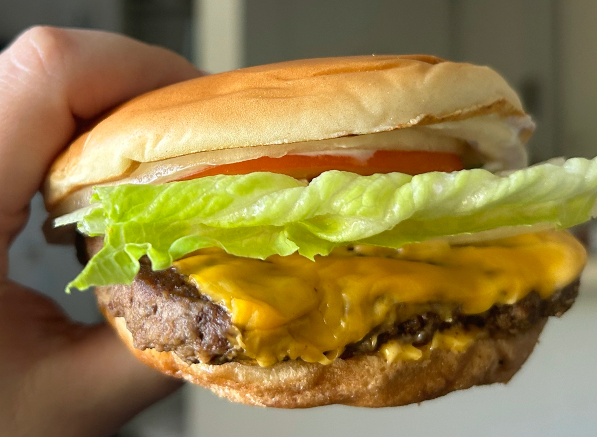 hand holding wendy's cheeseburger.