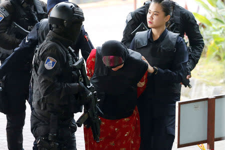 Indonesian Siti Aisyah, who is on trial for the killing of Kim Jong Nam, the estranged half-brother of North Korea's leader, is escorted as she arrives at the Shah Alam High Court on the outskirts of Kuala Lumpur, Malaysia August 16, 2018. REUTERS/Lai Seng Sin