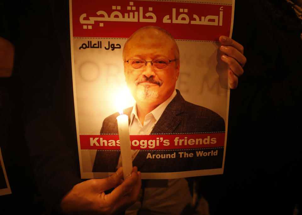 Activists, protesting the killing of Saudi journalist Jamal Khashoggi, hold a candlelight vigil outside Saudi Arabia's consulate in Istanbul, Thursday, Oct. 25, 2018. The poster reads in Arabic:' Khashoggi's Friends Around the World'. (AP Photo/Lefteris Pitarakis) 