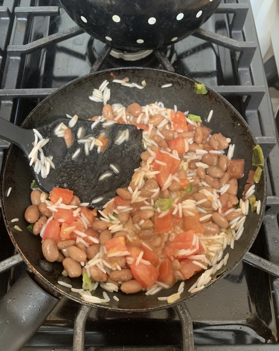 A pan of rice and beans with chopped tomato
