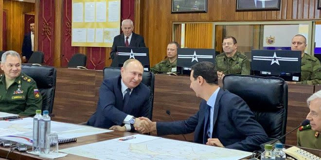 Russian President Vladimir Putin shakes hands with Syria's President Bashar al-Assad in Damascus