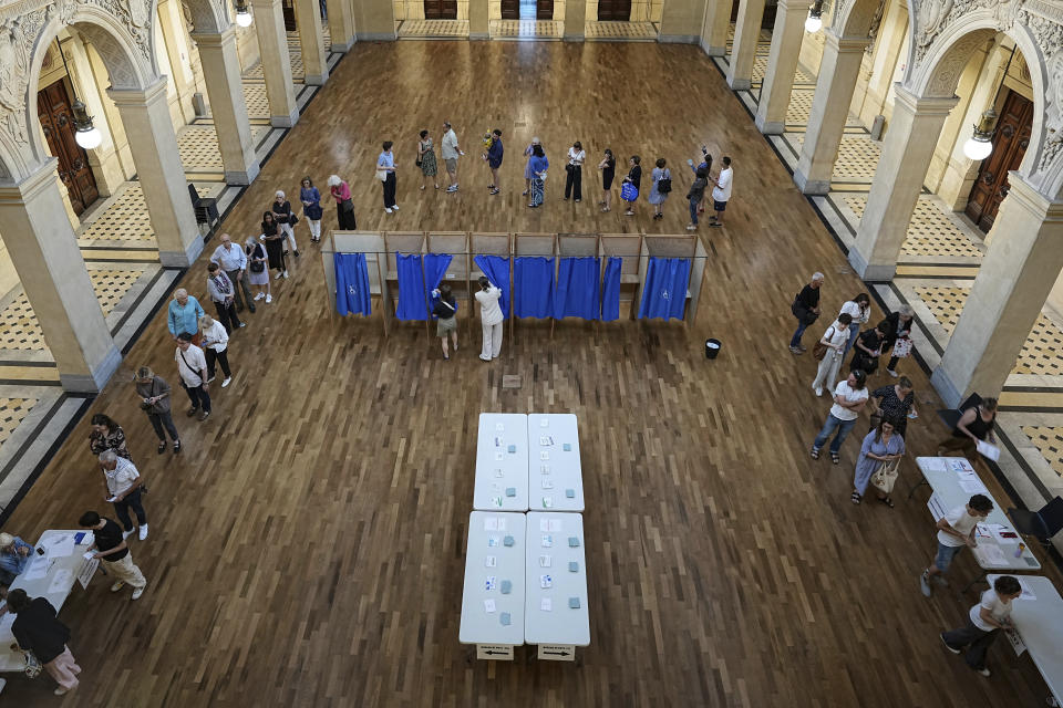 ARCHIVO - Franceses hacen fila para votar en la primera ronda de las elecciones parlamentarias francesas, en Lyon, Francia, el domingo 30 de junio de 2024. (AP Foto/Laurent Cipriani, archivo)