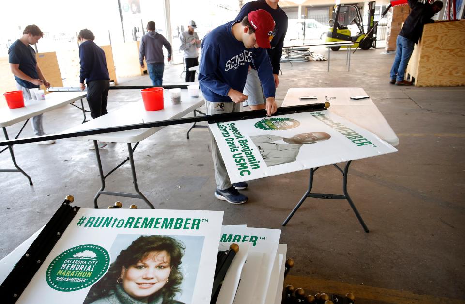 Cole Corley builds a banner for the Oklahoma City Memorial Marathon on March 25. The banners of 168 victims of the 1995 bombing line the road of during the annual race.