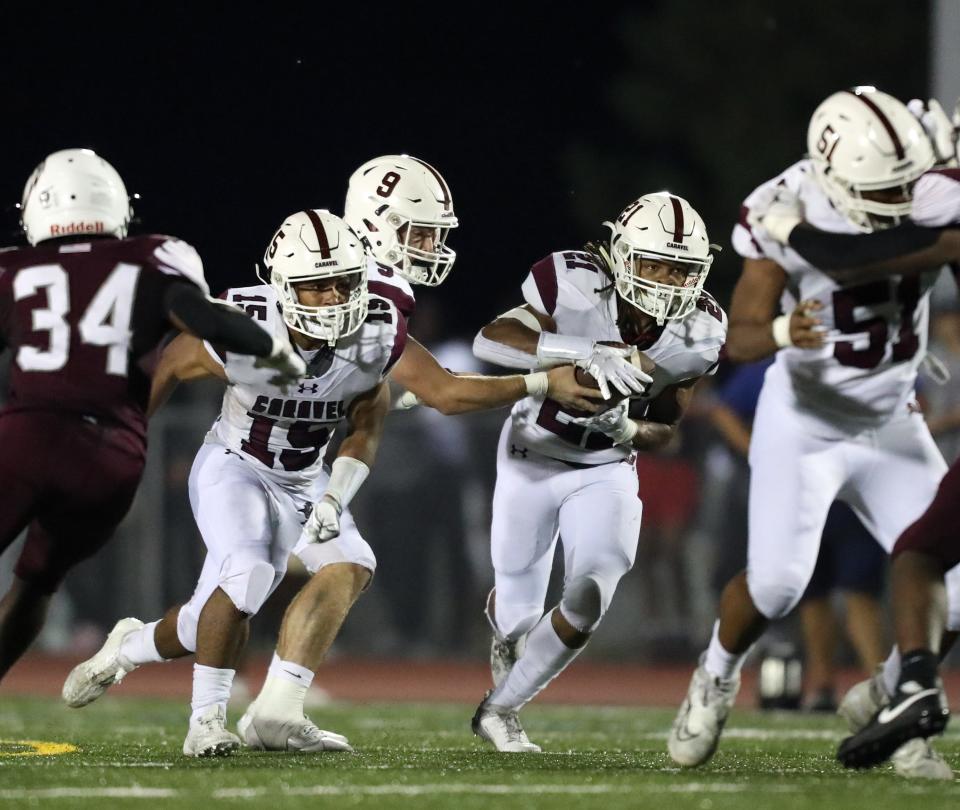 Caravel running back Craig Miller (21) charges up the middle during the Bucs' 28-13 win over Hodgson at Bob Peoples Stadium.