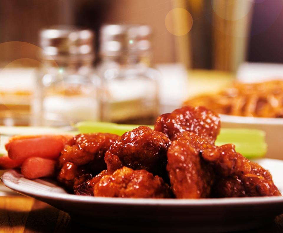 Chicken wings, fries, salt and pepper shakers, and a beer on a restaurant table