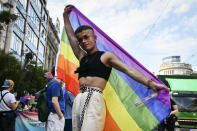 A participant poses with a rainbow flag during a gay pride parade in Budapest, Hungary, Saturday, July 24, 2021. Rising anger over policies of Hungary's right-wing government filled the streets of the country's capital on Saturday as thousands of LGBT activists and supporters marched in the city's Pride parade. (AP Photo/Anna Szilagyi)