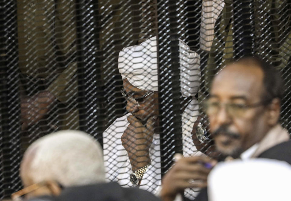 FILE - In this Saturday, Aug. 24, 2019 file photo, Sudan's autocratic former President Omar al-Bashir sits in a cage during his trial on corruption and money laundering charges, in Khartoum, Sudan. For the first time in three decades, Sudan has charted a path out of military rule following the formation of a power-sharing government by the pro-democracy movement and the generals who overthrew longtime autocrat Omar al-Bashir. (AP Photo, File)