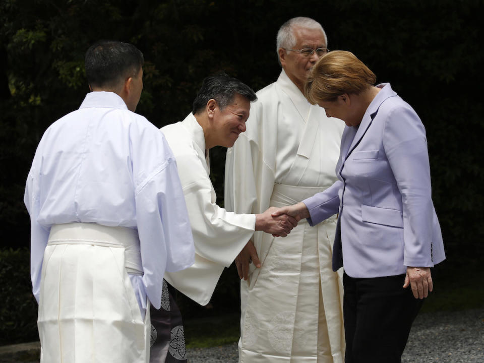 Angela Merkel wird im japanischen Ise von einem Shinto-Priester begr??t. Die Kanzlerin trifft dort mit den Regierungschefs der G7-L?nder zusammen. (Bild: Toru Hanai/Pool Photo via AP)