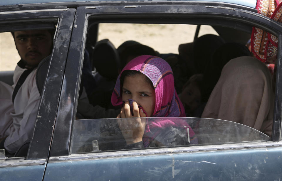 An Afghan family, who escaped from the volatile city of Ghazni, pose for a photograph in Maidan Shar, west of Kabul, Afghanistan, Monday, Aug. 13, 2018. Afghan Defense Minister Gen. Tareq Shah Bahrami said Monday that about 100 policemen and soldiers as well as 20 civilians have been killed in past four days of battle in the eastern capital of Ghazni. (AP Photo/Rahmat Gul)