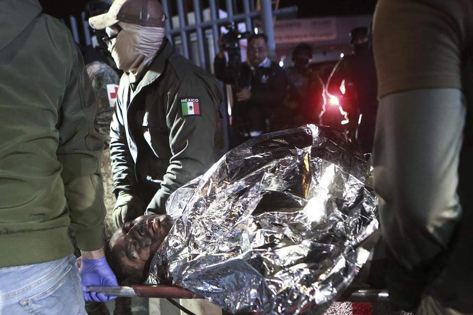 Paramedics carry a migrant who was wounded in a deadly fire at an immigration detention center in Ciudad Juarez, Mexico, Tuesday, March 28, 2023. (AP Photo/Christian Chavez)