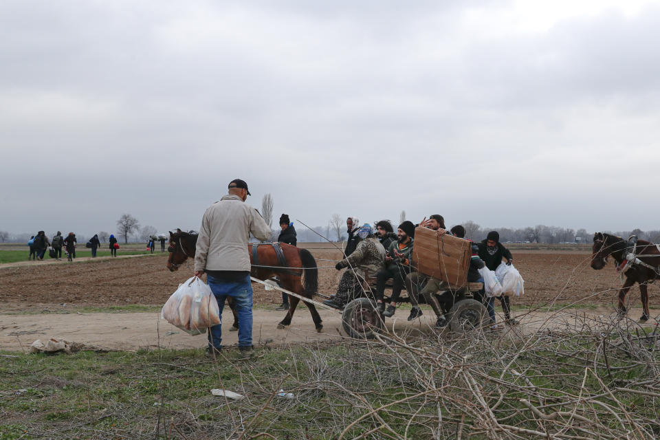 Migrants ride in a horse pulled cart near Pazarkule at the Turkish-Greek border on Thursday, March 5, 2020. Turkey has vowed to seek justice for a migrant it says was killed on the border with Greece after Greek authorities fired tear gas and stun grenades to push back dozens of people attempting to cross over. Greece had denied that anyone was killed in the clashes. (AP Photo/Darko Bandic)