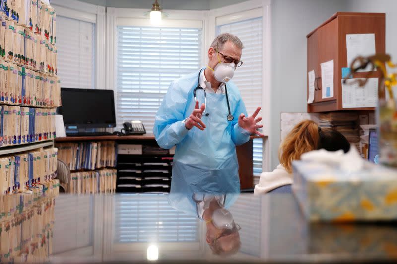 Dr Greg Gulbransen speaks with a medical assistant while maintaining visits with both his regular patients and those confirmed to have the coronavirus disease (COVID-19) at his pediatric practice in Oyster Bay, New York