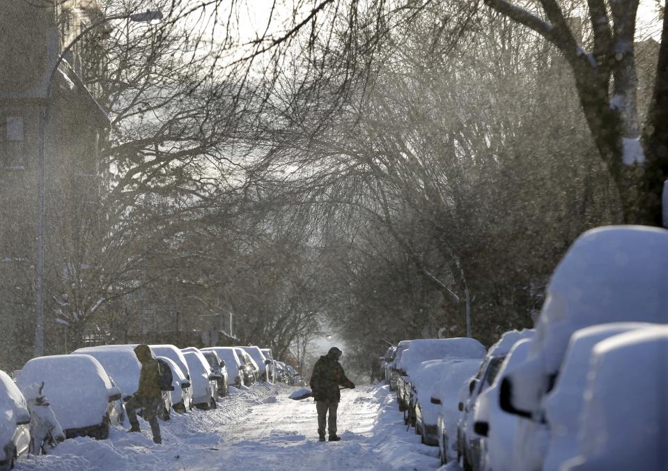 A man shovels snow off his car in the Brooklyn borough of New York, Wednesday, Jan. 22, 2014. A winter storm stretched from Kentucky to New England and hit hardest along the heavily populated Interstate 95 corridor between Philadelphia and Boston. Snow began falling at midmorning Tuesday in Philadelphia and dumped as much as 14 inches by Wednesday morning, with New York seeing almost as much. (AP Photo/Seth Wenig)