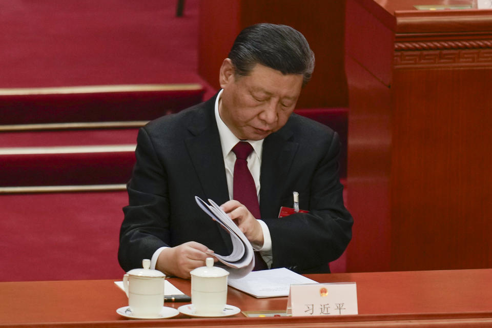 Chinese President Xi Jinping looks through documents during the opening session of the National People's Congress (NPC) at the Great Hall of the People in Beijing, China, Tuesday, March 5, 2024. (AP Photo/Ng Han Guan)