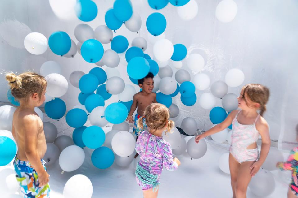 Children play inside a plastic bubble filled with balloons during July Summer Splash at Downtown Palm Beach Gardens on July 6, 2023 in Palm Beach Gardens, Florida. 